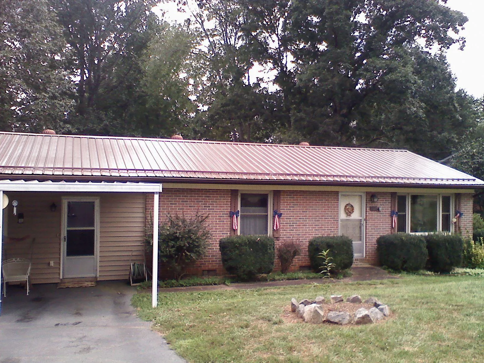 Bronze metal roof and carport on a brick ranch home — Roof Repair work by our crew in East China